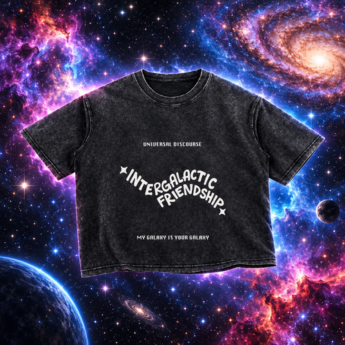 A short-sleeve crewneck t-shirt in a washed black or charcoal gray color, featuring white text graphics on the front. The text reads 'INTERGALACTIC FRIENDSHIP' in a curved, stylized font, with 'UNIVERSAL DISCOURSE' above and 'MY GALAXY IS YOUR GALAXY' below.